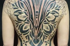 Tatuaje blackwork en espalda completa con diseño de alas florales simétricas, patrones geométricos y líneas precisas. Tatuaje blackwork por Agu en Hipno Tattoo Estepona.